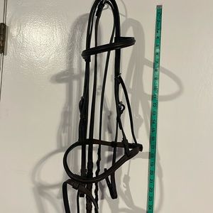 Unused but older dark brown schooling bridle with braided reins